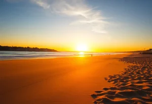 Sunset view of a beach in Rhode Island with golden sands and gentle waves.